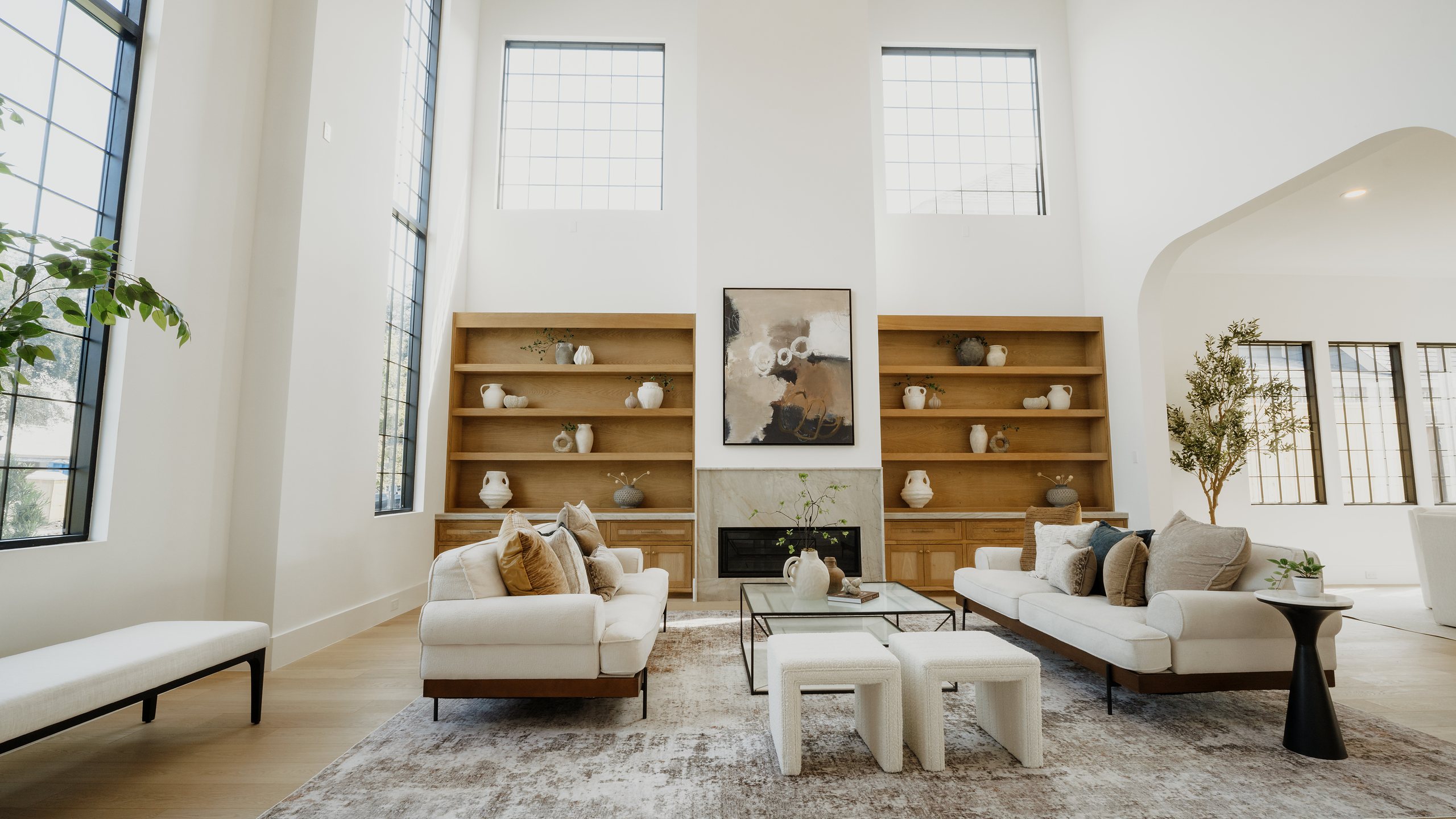 Two-story living room with built-in oak shelving and a marble fireplace